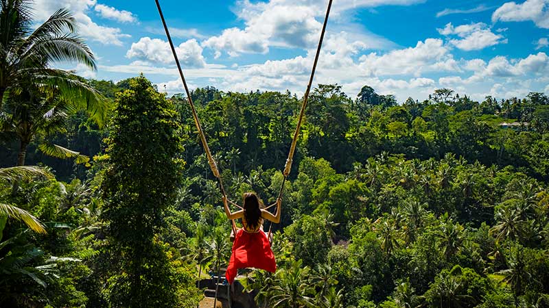 Woman with long swing and forest view