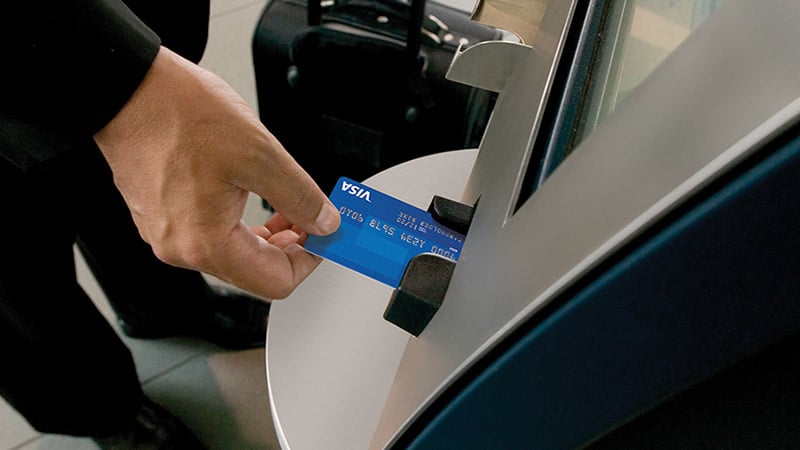 Person using an ATM overseas with their Visa EMV chip card