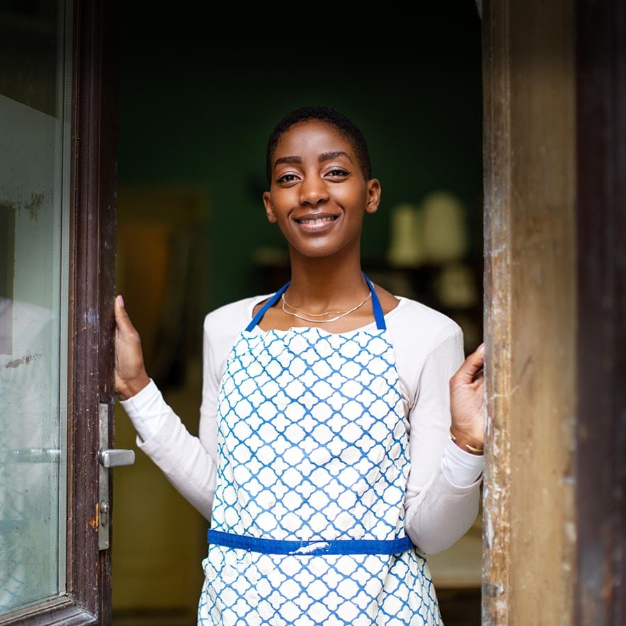 A woman standing in a doorway, representing the way Visa's digital payment options open doors for inclusivity around the globe